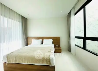 Spacious modern bedroom with large windows and elegant decor
