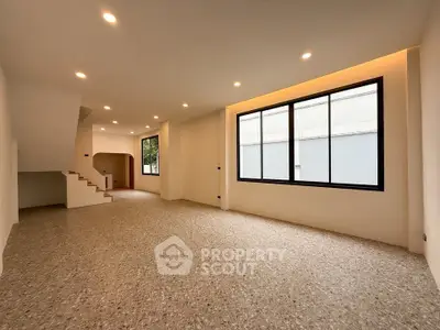 Spacious modern living room with large windows and elegant lighting