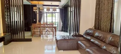 Luxurious living room with leather sofa and elegant dining area in modern home