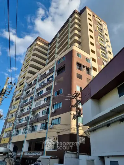 Modern high-rise building with multiple balconies and urban surroundings.