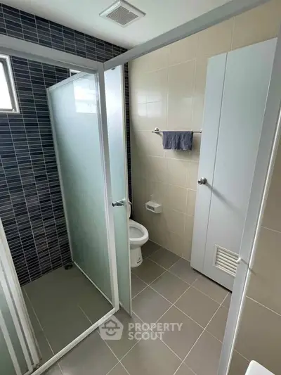 Modern bathroom with glass shower enclosure and sleek tile design