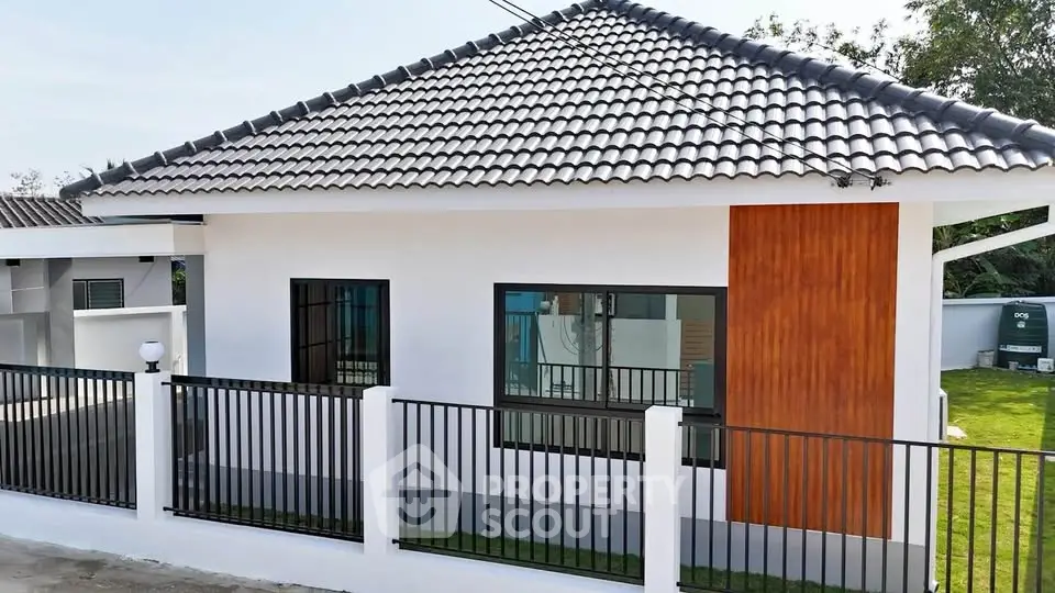 Modern single-story house with tiled roof and fenced yard