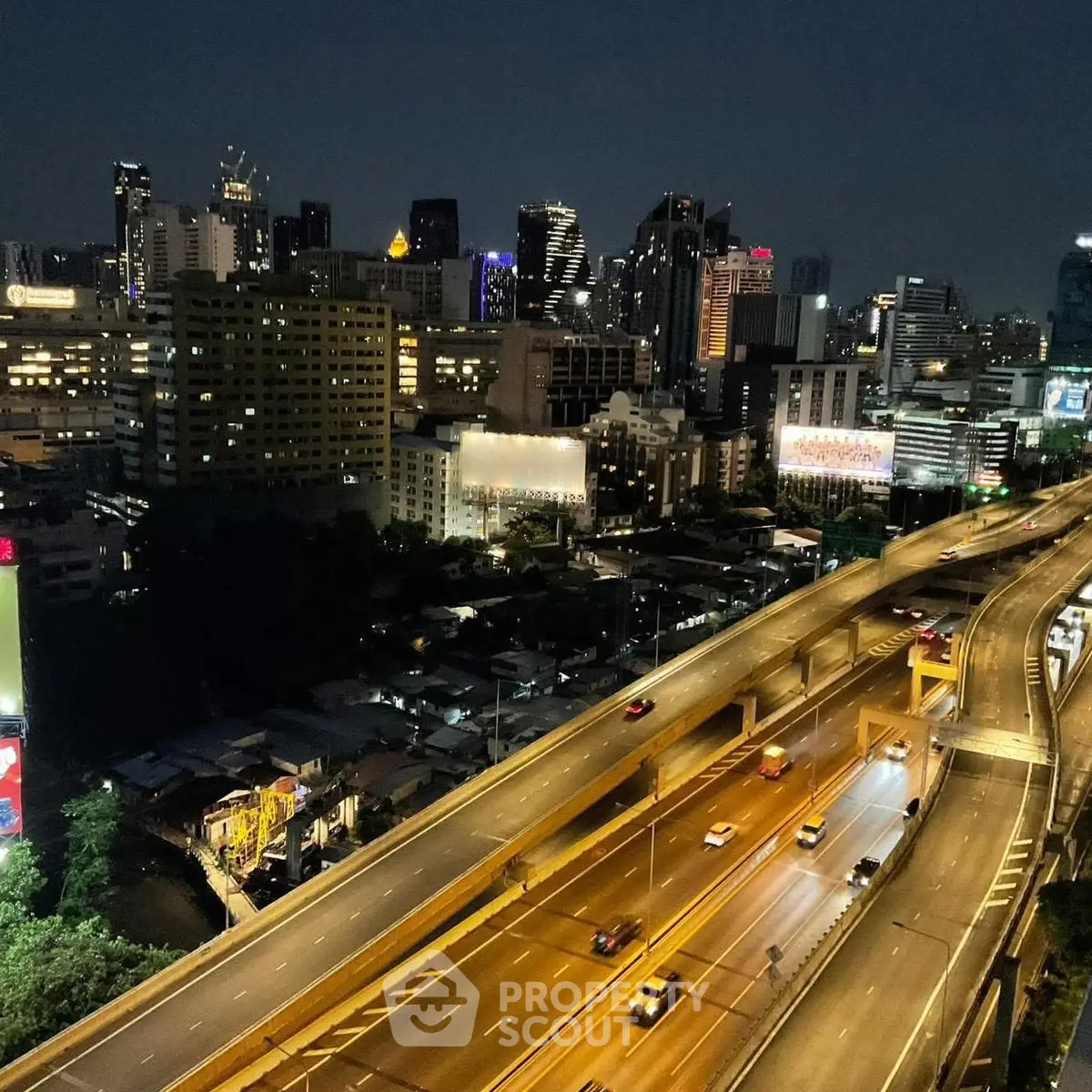 Stunning cityscape view with illuminated skyline and busy highway at night, perfect for urban living enthusiasts.