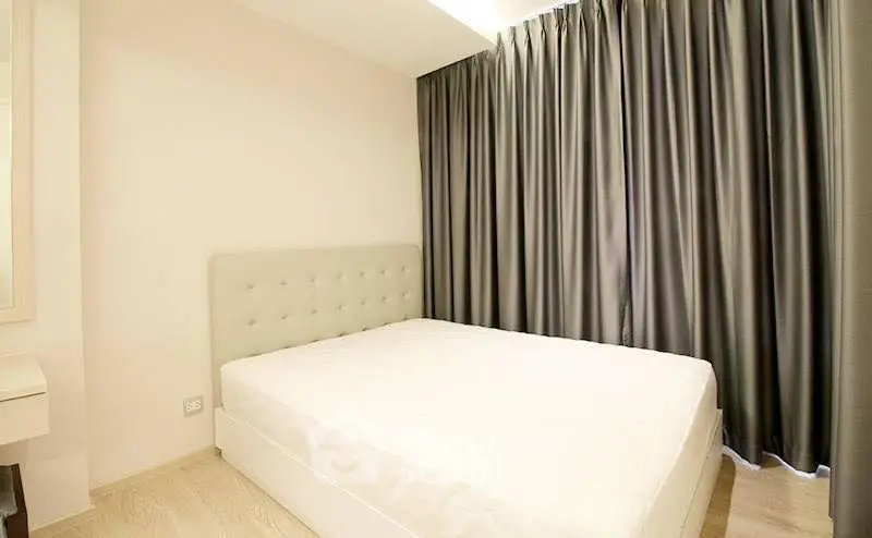Modern bedroom with elegant curtains and a comfortable bed in a stylish apartment.