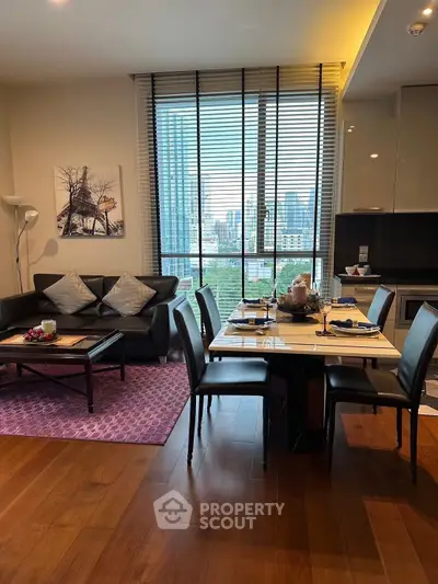 Modern living room with city view, stylish furniture, and elegant dining area in a high-rise apartment.