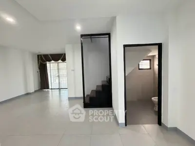 Spacious modern interior with staircase and large windows, ideal for open living.