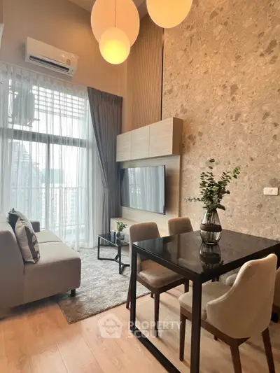 Modern living room with high ceiling, elegant decor, and large windows for natural light.