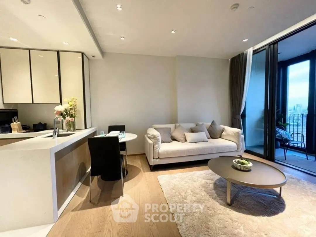 Modern living room with open kitchen and balcony view in luxury apartment.
