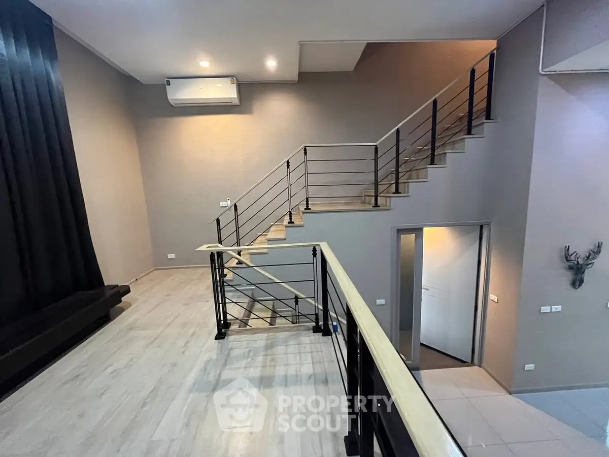 Modern duplex interior with sleek staircase and high ceilings