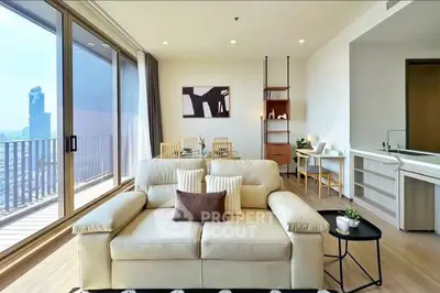 Modern living room with balcony and city view, featuring stylish furniture and open layout.