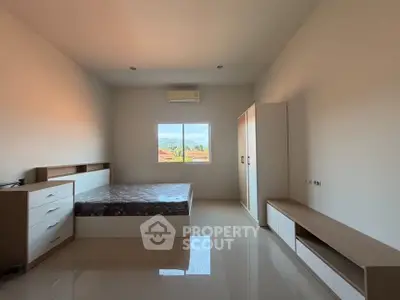 Spacious bedroom with modern furniture and scenic window view, perfect for comfortable living.