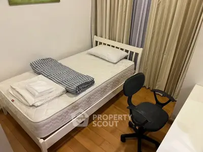 Cozy bedroom with single bed, wooden flooring, and office chair, ideal for a compact living space.