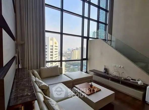 Luxurious living room with floor-to-ceiling windows and stunning city view in modern high-rise apartment.