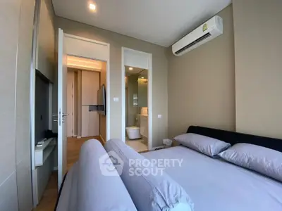 Modern bedroom with ensuite bathroom and air conditioning in luxury apartment