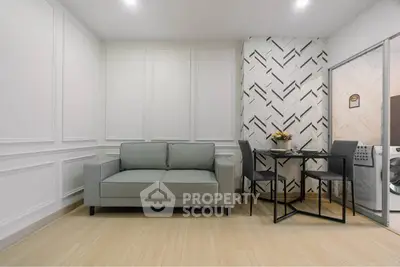Modern living room with stylish decor and dining area, featuring a cozy sofa and elegant wall design.