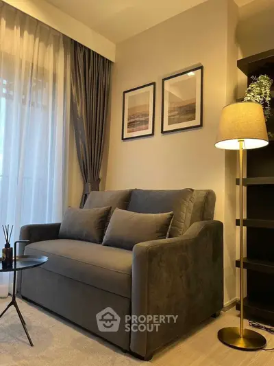 Cozy living room with elegant sofa, floor lamp, and framed art, perfect for relaxation.