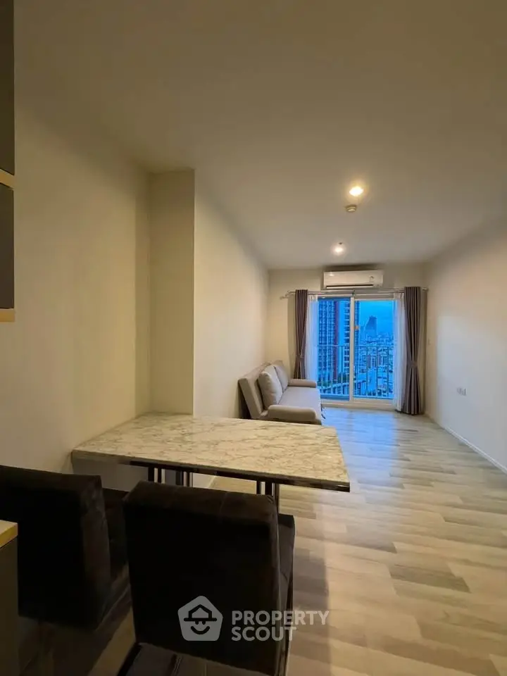 Modern living room with city view, featuring sleek furniture and large windows for natural light.