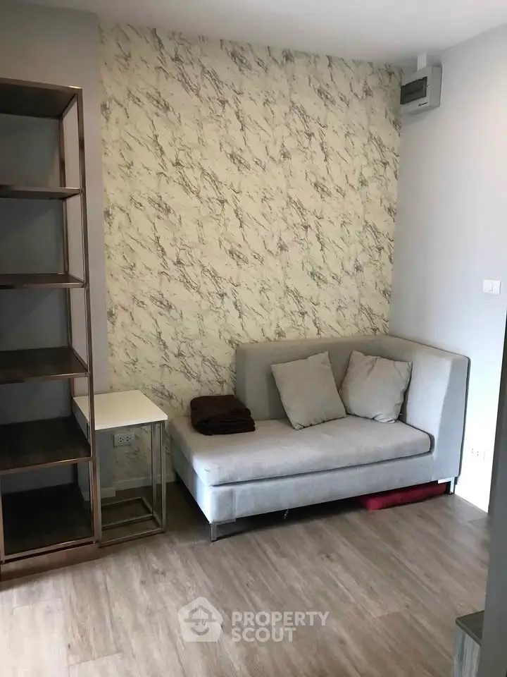 Modern living room with stylish sofa and marble accent wall, perfect for cozy urban living.