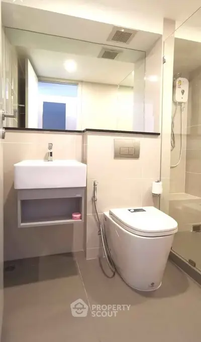 Modern bathroom with sleek fixtures and glass shower enclosure in a contemporary apartment.