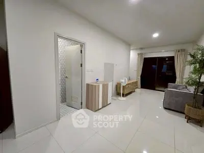 Modern living room with sleek design and open layout, featuring stylish furniture and bright lighting.