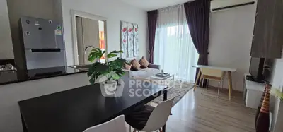Modern living room with open kitchen, stylish decor, and natural light.