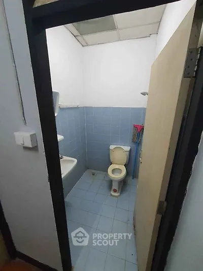 Compact bathroom with blue tiles and basic fixtures