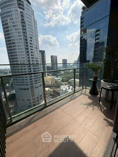 Stunning cityscape view from a modern high-rise balcony with glass railing.