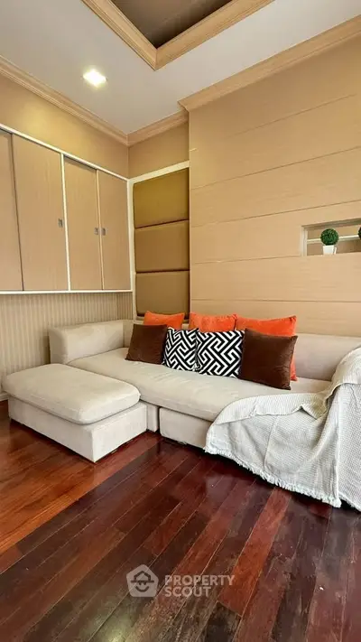 Cozy living room with stylish sectional sofa and warm wooden flooring