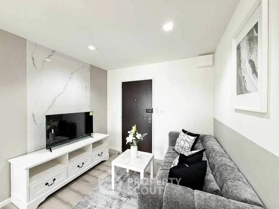 Modern living room with stylish decor and sleek furniture, featuring a cozy gray sofa and elegant TV stand.