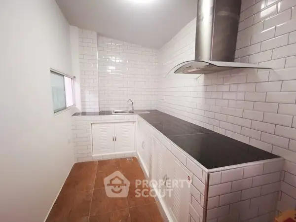 Modern kitchen with sleek black countertops and white subway tiles