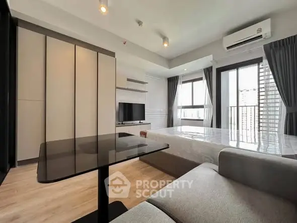 Modern studio apartment with sleek design and large windows offering city views.