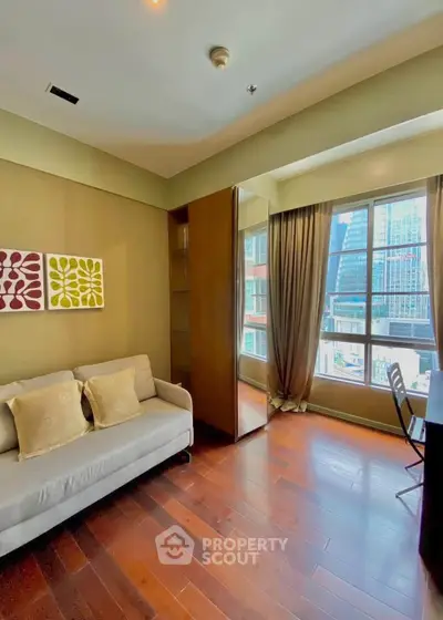 Chic urban living room with large window and stylish decor in a high-rise apartment.