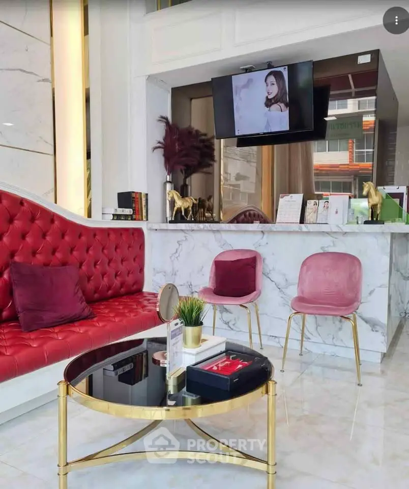 Luxurious modern living room with red and pink seating, marble accents, and stylish decor.