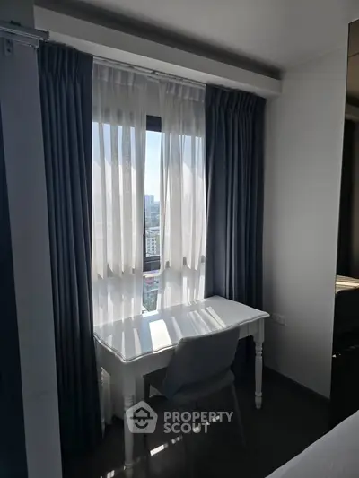 Cozy study nook with a view, featuring a sleek white desk and elegant curtains in a modern apartment.