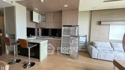 Modern open-layout kitchen with sleek appliances and cozy living area, perfect for urban living.