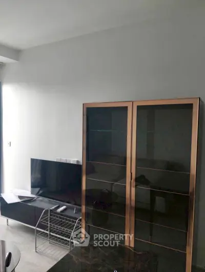 Modern living room with sleek TV setup and stylish glass cabinet