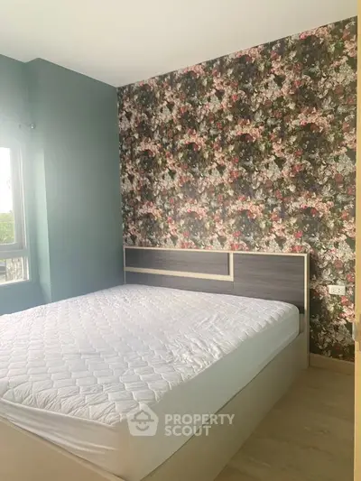 Charming bedroom with floral accent wall and natural light