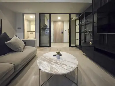 Modern living room with elegant marble coffee table and cozy sofa, featuring sleek glass doors and stylish decor.
