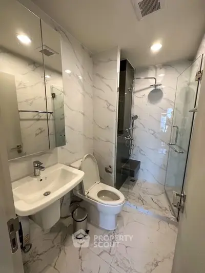 Modern bathroom with marble tiles and glass shower enclosure