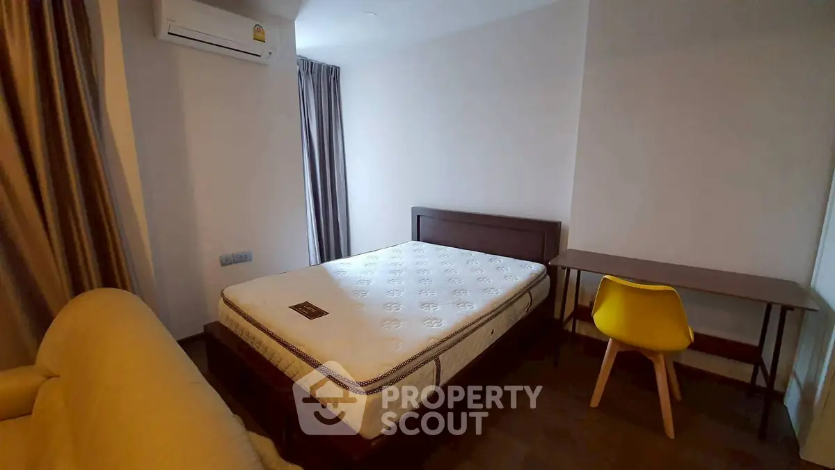 Cozy bedroom with modern furnishings, featuring a comfortable bed, stylish desk, and air conditioning.