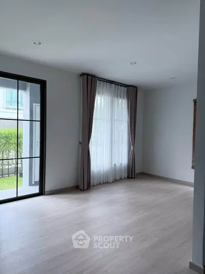 Spacious empty living room with large window and garden view