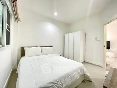 Bright and cozy bedroom with modern white wardrobe and comfortable bed in a minimalist style.