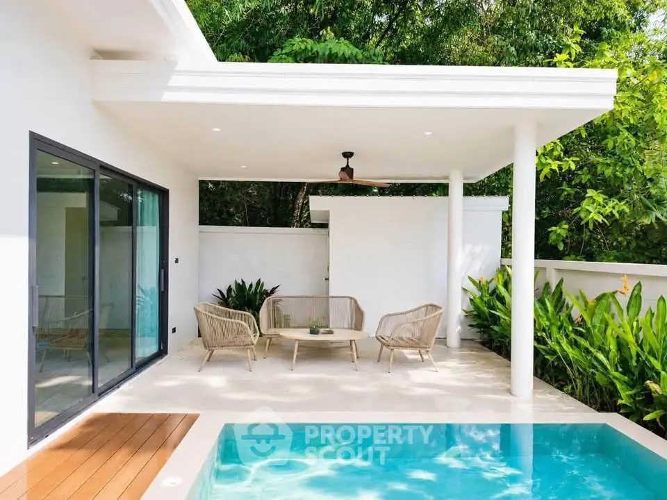 Luxurious modern patio with pool and stylish outdoor seating, surrounded by lush greenery.