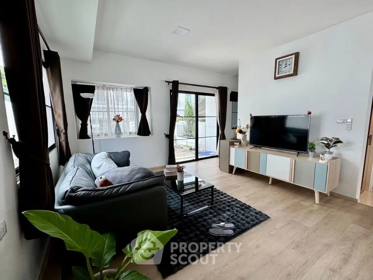 Modern living room with sleek furniture and large windows for natural light.