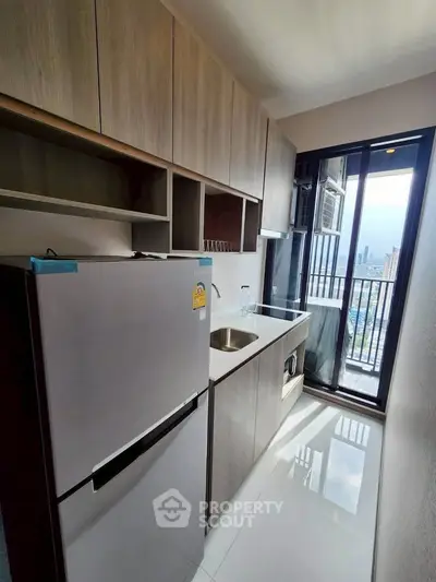 Modern kitchen with sleek cabinetry and city view from balcony