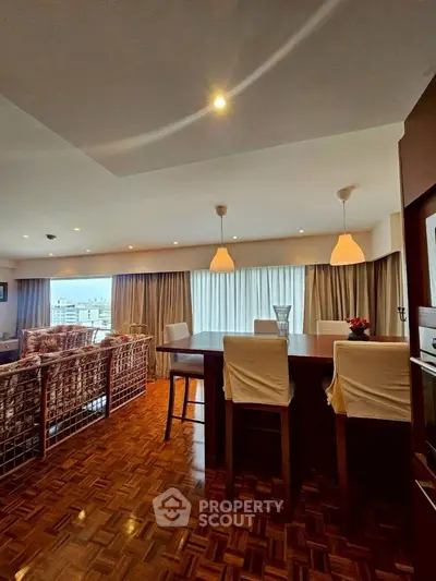 Spacious open-plan living and dining area with elegant lighting and city view.