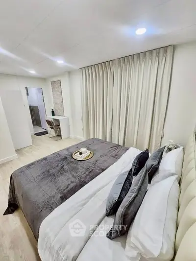 Elegant bedroom with plush bedding and modern decor, perfect for a cozy retreat.