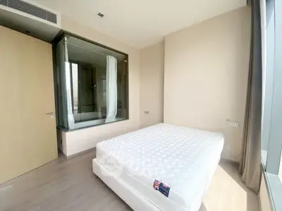 Modern bedroom with large window and ensuite bathroom in luxury apartment