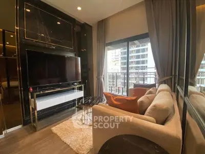Modern living room with large TV, cozy sofa, and balcony view in luxury apartment.