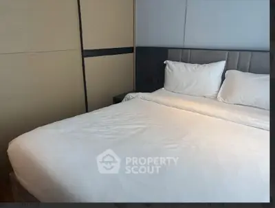 Modern bedroom with cozy bed and stylish headboard in a contemporary apartment.